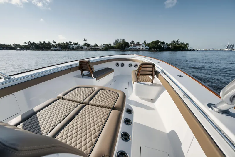 Slide: The Image of 2023 Valhalla Boatworks V-41 luxury boat interior with cushioned seating, on calm water. - 15