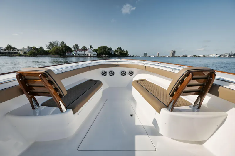 Slide: The Image of 2023 Valhalla Boatworks V-41 interior with luxurious seating, overlooking serene waterfront homes. - 16
