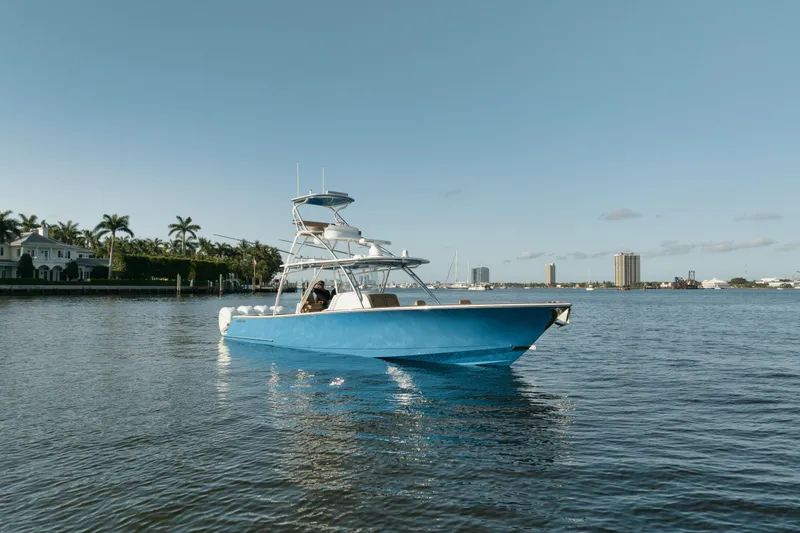 Slide: The Image of 2023 Valhalla Boatworks V-41 in blue on calm water, cityscape background. - 4