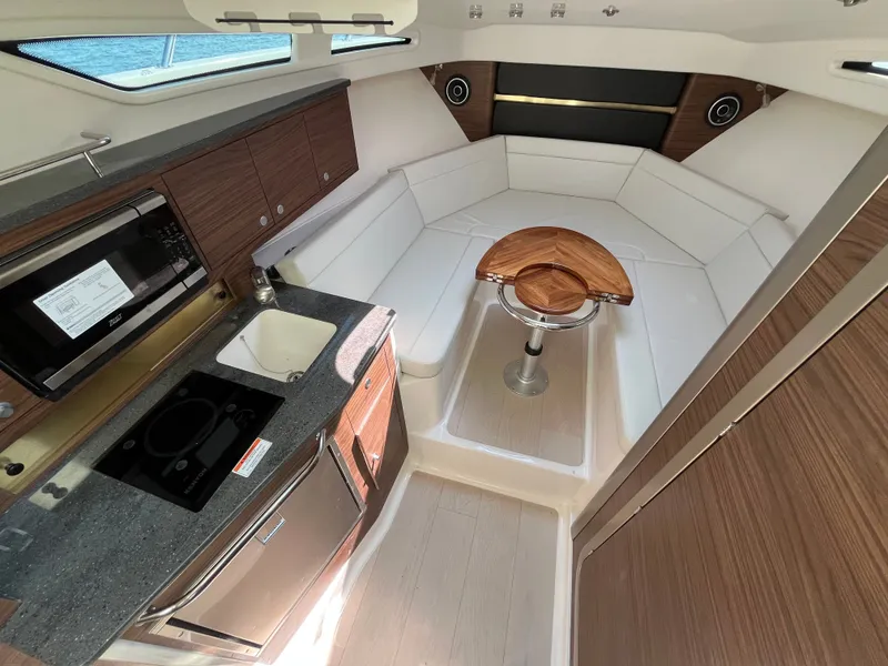 Slide: The Image of The 2026 Boston Whaler 325 Conquest cabin features a modern kitchenette and cozy seating area. - 39