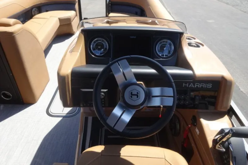 Slide: The Image of Steering console of 2026 Harris Solstice 250 boat with tan seating and modern dashboard. - 2