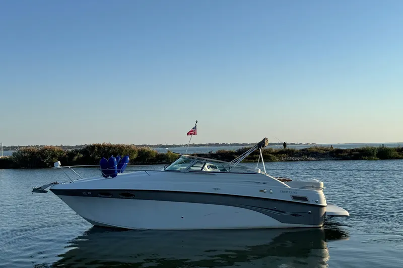 The Image of 2003 Crownline 262 CR boat on calm water with clear sky background. - 0