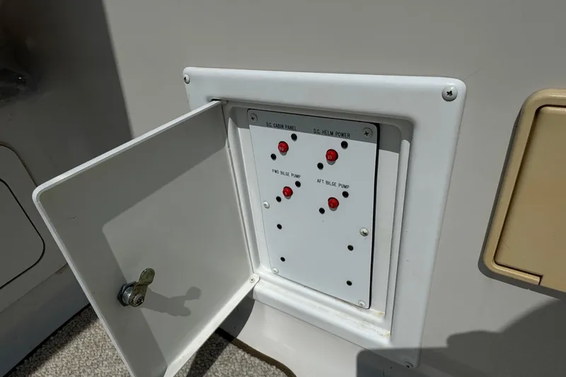 Slide: The Image of Open electrical panel on 2003 Crownline 262 CR boat, showing switches and indicators. - 21