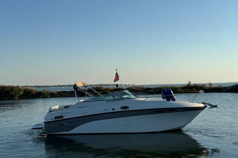 Slide: The Image of 2003 Crownline 262 CR boat on calm water with clear sky background. - 3