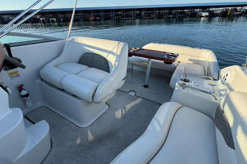 Slide: The Image of 2003 Crownline 262 CR boat interior with white seating and wooden table. - 34