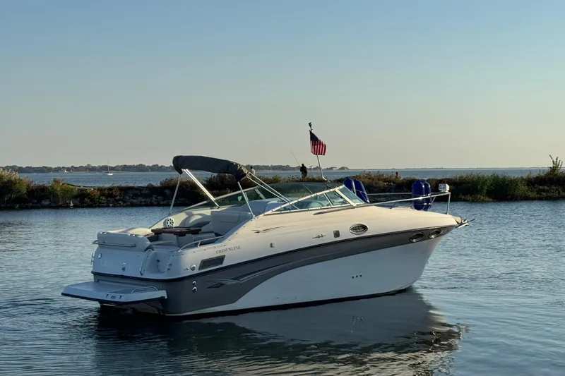 Slide: The Image of 2003 Crownline 262 CR boat on calm water, American flag, scenic background. - 4