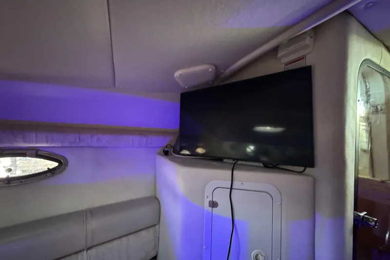 Slide: The Image of Interior of 2003 Crownline 262 CR boat with mounted TV and ambient lighting. - 40