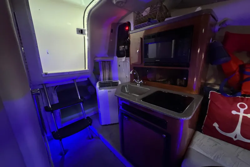 Slide: The Image of Interior of 2003 Crownline 262 CR boat with kitchenette and nautical decor. - 41