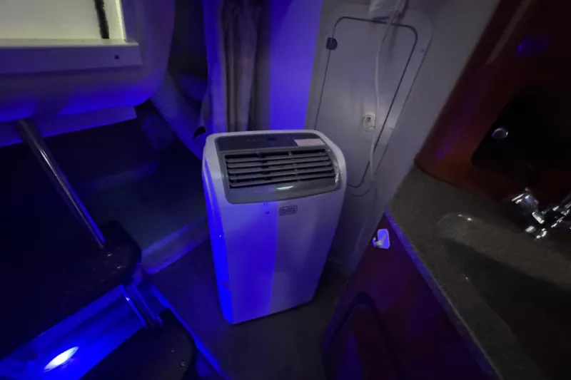 Slide: The Image of Portable air conditioner inside 2003 Crownline 262 CR boat cabin, illuminated by blue light. - 42