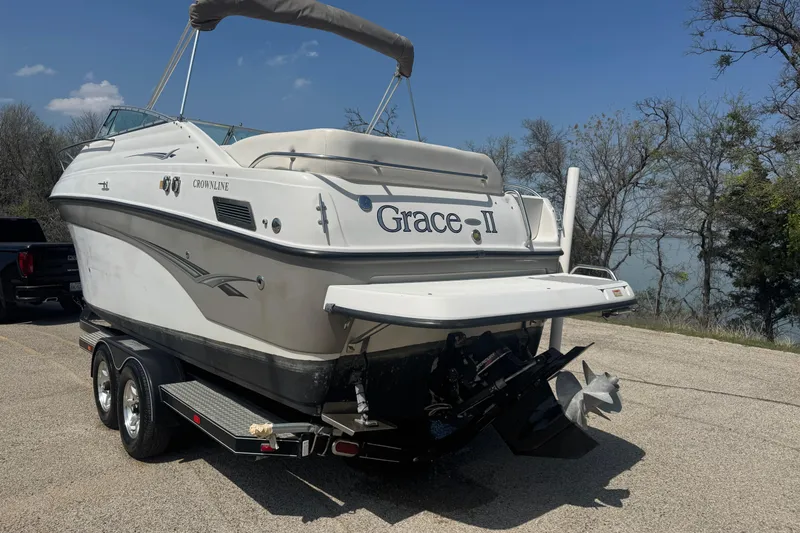 Slide: The Image of 2003 Crownline 262 CR boat named "Grace-II" on a trailer by a lake. - 8
