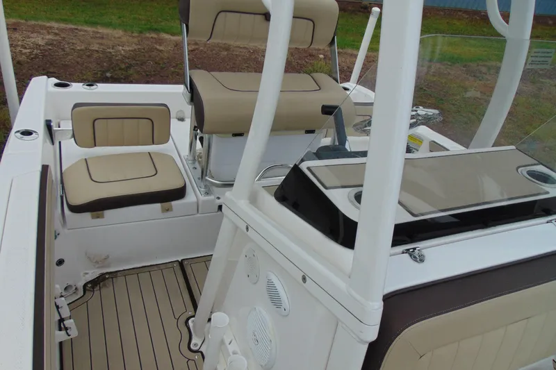 Slide: The Image of 2021 Yamaha 195 FSH Sport boat interior with beige seating and console. - 11