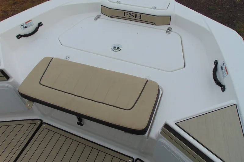 Slide: The Image of 2021 Yamaha 195 FSH Sport boat interior with cushioned seating and storage. - 13