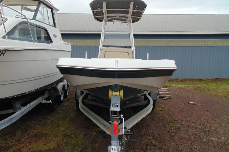 Slide: The Image of 2021 Yamaha 195 FSH Sport boat on trailer, parked beside another boat. - 2