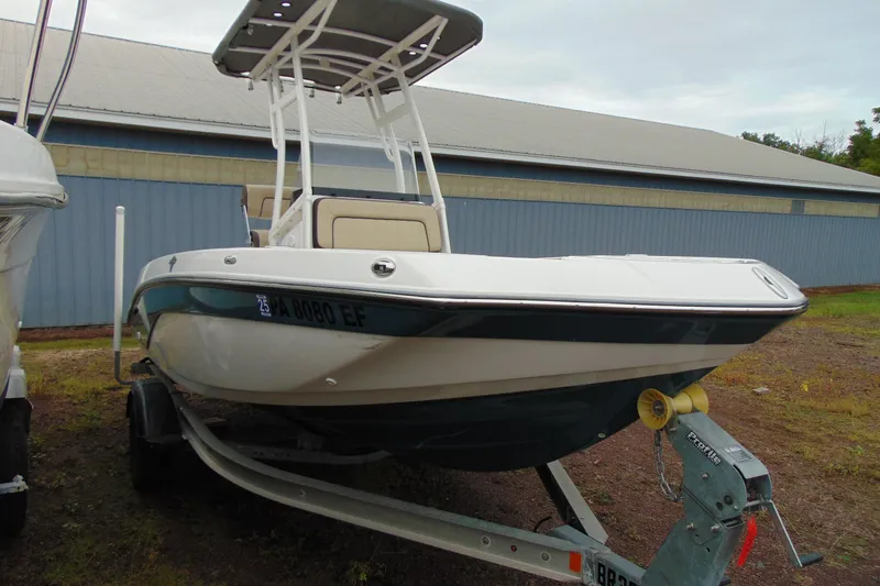 Slide: The Image of 2021 Yamaha 195 FSH Sport boat on trailer, parked outdoors near a blue building. - 3