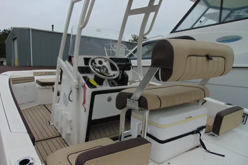 Slide: The Image of 2021 Yamaha 195 FSH Sport boat interior with beige seating and steering console. - 7