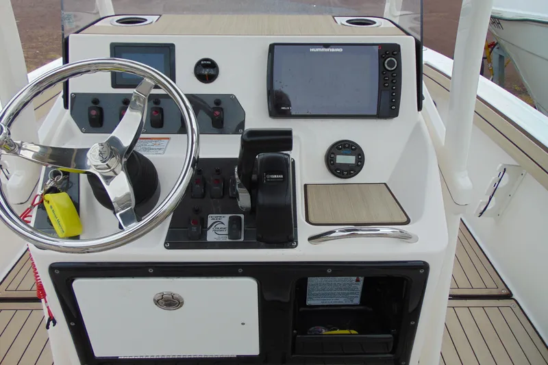 Slide: The Image of 2021 Yamaha 195 FSH Sport boat dashboard with steering wheel and navigation controls. - 9