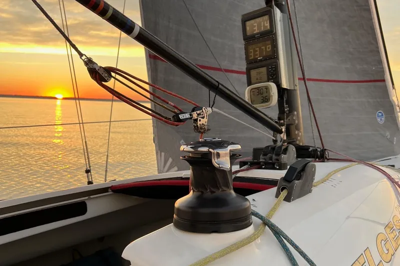 Slide: The Image of Melges 32 sailboat at sunset, showcasing rigging and digital displays, 2010 model. - 6