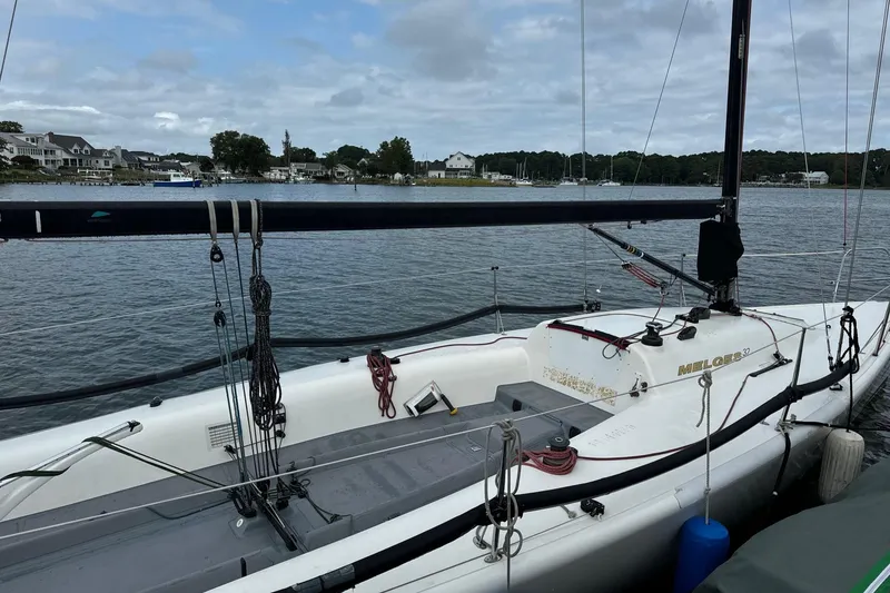 Slide: The Image of 2010 Melges 32 sailboat docked by a scenic waterfront with houses in the background. - 9