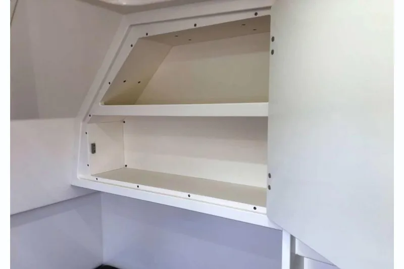 Slide: The Image of Manufacturer Provided Image: 2025 Scout 330 LXF boat interior storage compartment with open shelves. - 12