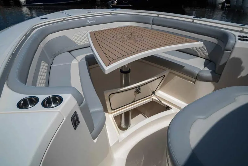 Slide: The Image of Manufacturer Provided Image: 2025 Scout 330 LXF boat interior with cushioned seating and wooden table. - 6
