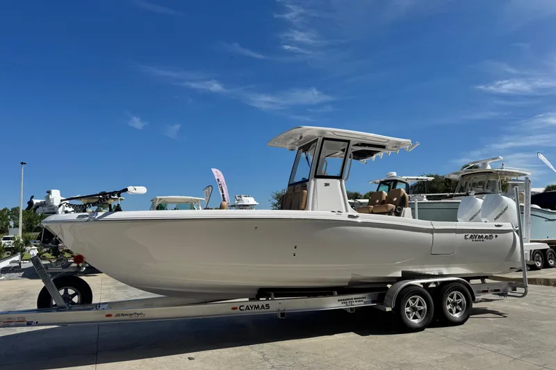 The Image of 2026 Caymas 291 boat on trailer under clear blue sky. - 1