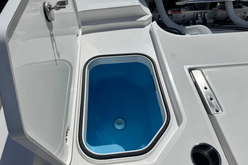 Slide: The Image of 2026 Caymas 291 boat livewell with open lid, showcasing blue interior. - 13