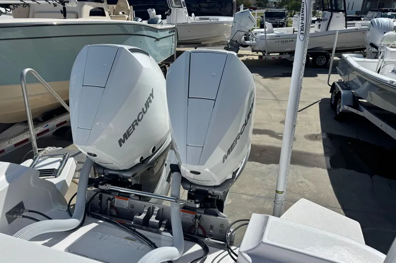 Slide: The Image of Twin Mercury outboard engines on a 2026 Caymas 291 boat, docked in a marina. - 14