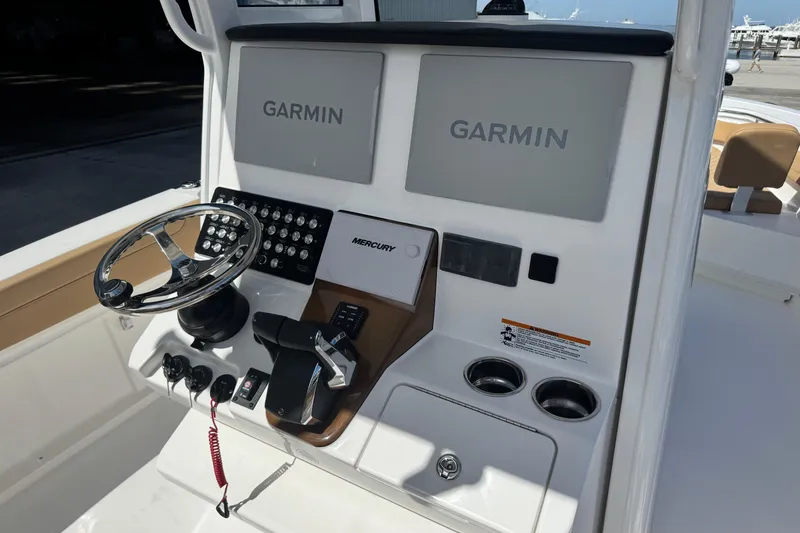Slide: The Image of 2026 Caymas 291 boat dashboard with Garmin displays and Mercury controls. - 17