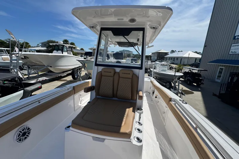Slide: The Image of 2026 Caymas 291 boat interior with tan seating, docked at a marina under a clear sky. - 24