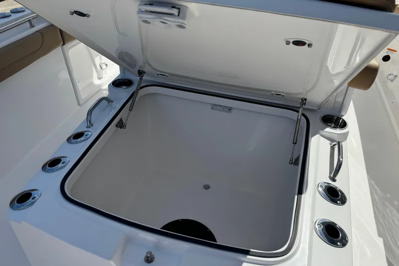 Slide: The Image of Open storage compartment on 2026 Caymas 291 boat, featuring multiple cup holders and handles. - 25