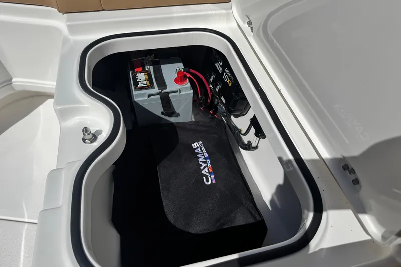 Slide: The Image of 2026 Caymas 291 boat battery compartment with wiring and branded cover. - 26