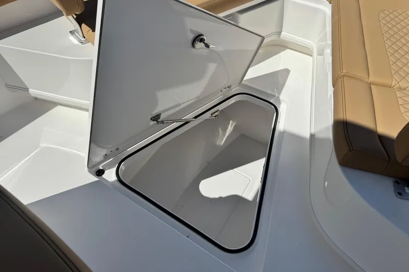 Slide: The Image of Open storage compartment on 2026 Caymas 291 boat with tan seating. - 29