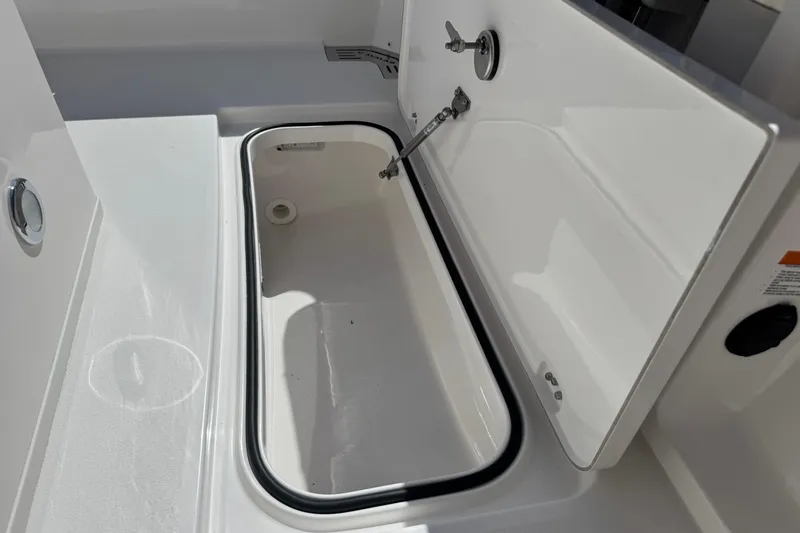 Slide: The Image of 2026 Caymas 291 boat storage compartment with open lid, showcasing interior space. - 31