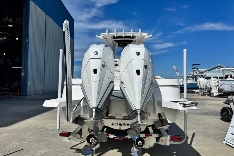 Slide: The Image of 2026 Caymas 291 boat with dual outboard motors at a marina. - 5