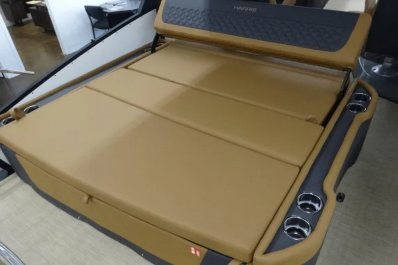 Slide: The Image of 2026 Harris Sunliner 250 boat interior with tan seating and cup holders. - 13