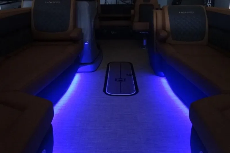 Slide: The Image of 2026 Harris Sunliner 250 interior with ambient blue LED lighting and luxurious seating. - 20