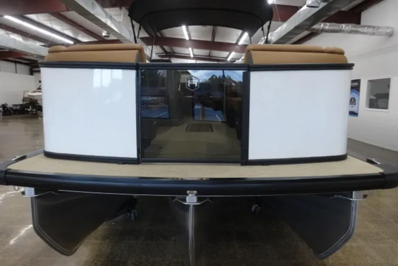Slide: The Image of 2026 Harris Sunliner 250 pontoon boat in showroom, rear view with seating and canopy. - 9