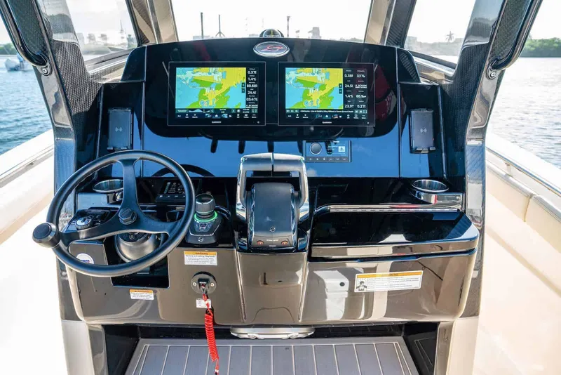 Slide: The Image of Manufacturer Provided Image: 2026 Scout 288 LXF boat dashboard with dual navigation screens and steering wheel. - 6