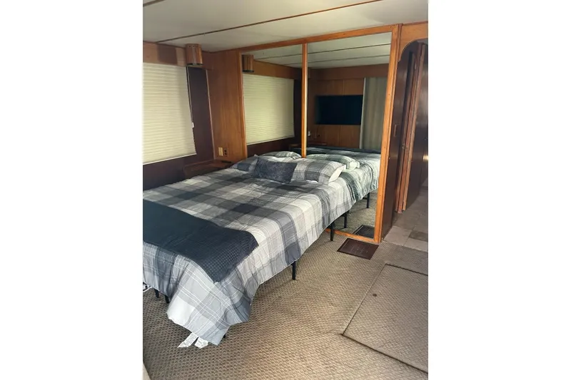 Slide: The Image of Cozy bedroom interior of 1988 Lazy Days houseboat with plaid bedding and mirrored closet. - 11
