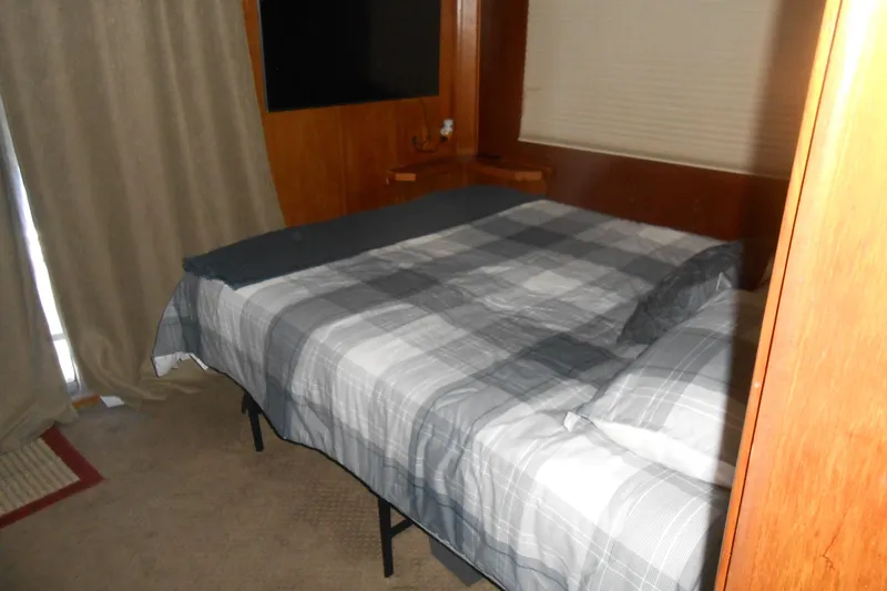 Slide: The Image of Cozy bedroom with plaid bedding in a 1988 Lazy Days houseboat. - 12