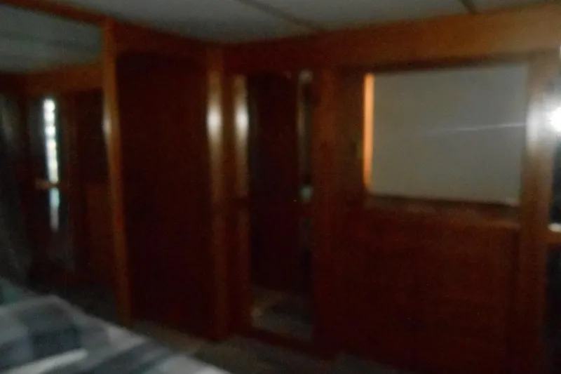 Slide: The Image of Dimly lit interior of a 1988 Lazy Days houseboat with wooden paneling. - 13