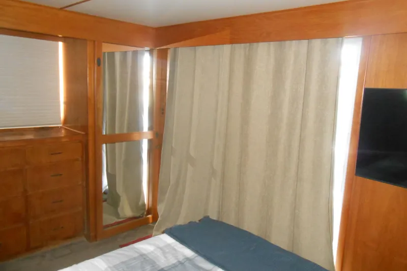 Slide: The Image of Interior of 1988 Lazy Days houseboat with wood paneling, curtains, and a dresser. - 14