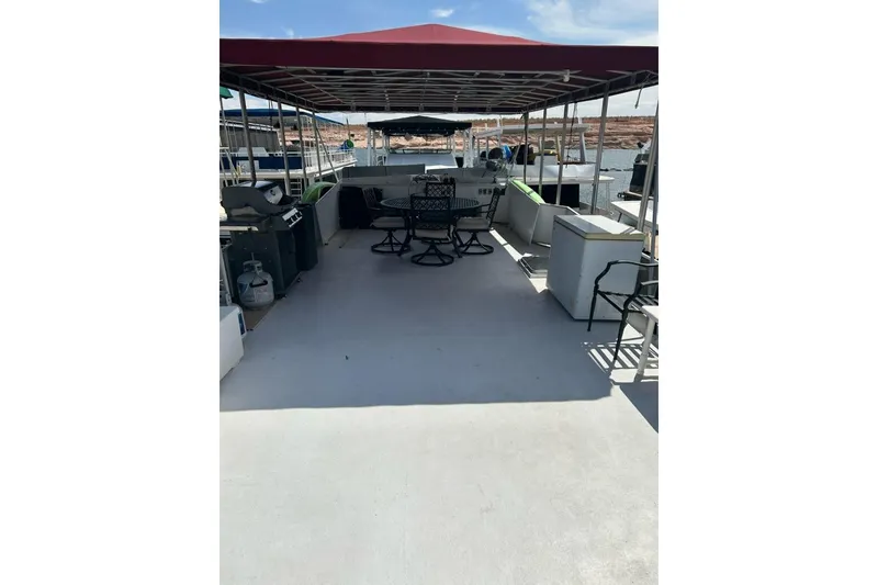 Slide: The Image of 1988 Lazy Days houseboat deck with seating, grill, and canopy on a sunny day. - 16