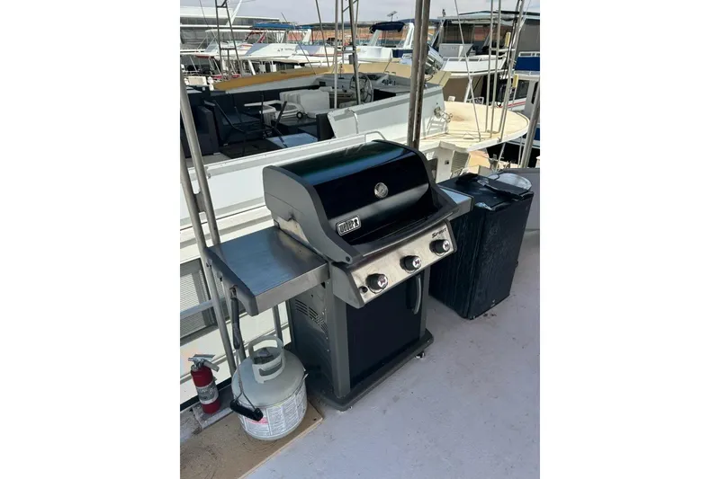 Slide: The Image of Outdoor grill on 1988 Lazy Days houseboat deck, with propane tank and fire extinguisher nearby. - 17