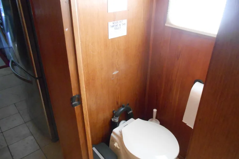 Slide: The Image of Houseboat bathroom interior with wooden walls, toilet, and a small window. - 20