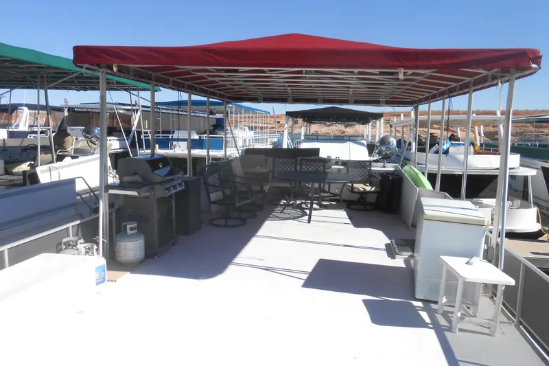 Slide: The Image of 1988 Lazy Days houseboat deck with red canopy, outdoor furniture, and grill. - 28