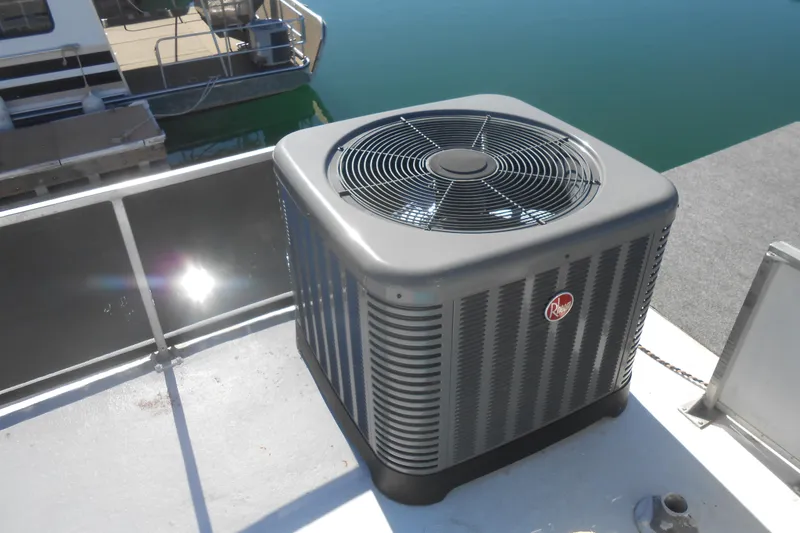 Slide: The Image of Rooftop air conditioning unit on 1988 Lazy Days houseboat, docked by calm water. - 33