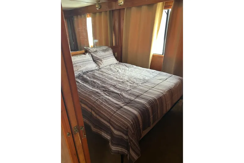 Slide: The Image of Interior of 1988 Lazy Days houseboat with kitchen, bar stools, and wall-mounted TV. - 5