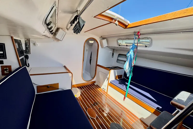 Slide: The Image of Interior of 1999 J Boats J/105 sailboat with blue seating and wooden accents. - 15