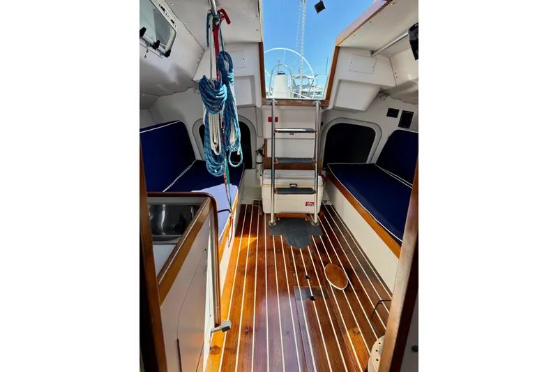 Slide: The Image of Interior of 1999 J Boats J/105 sailboat with wooden flooring and blue seating. - 16